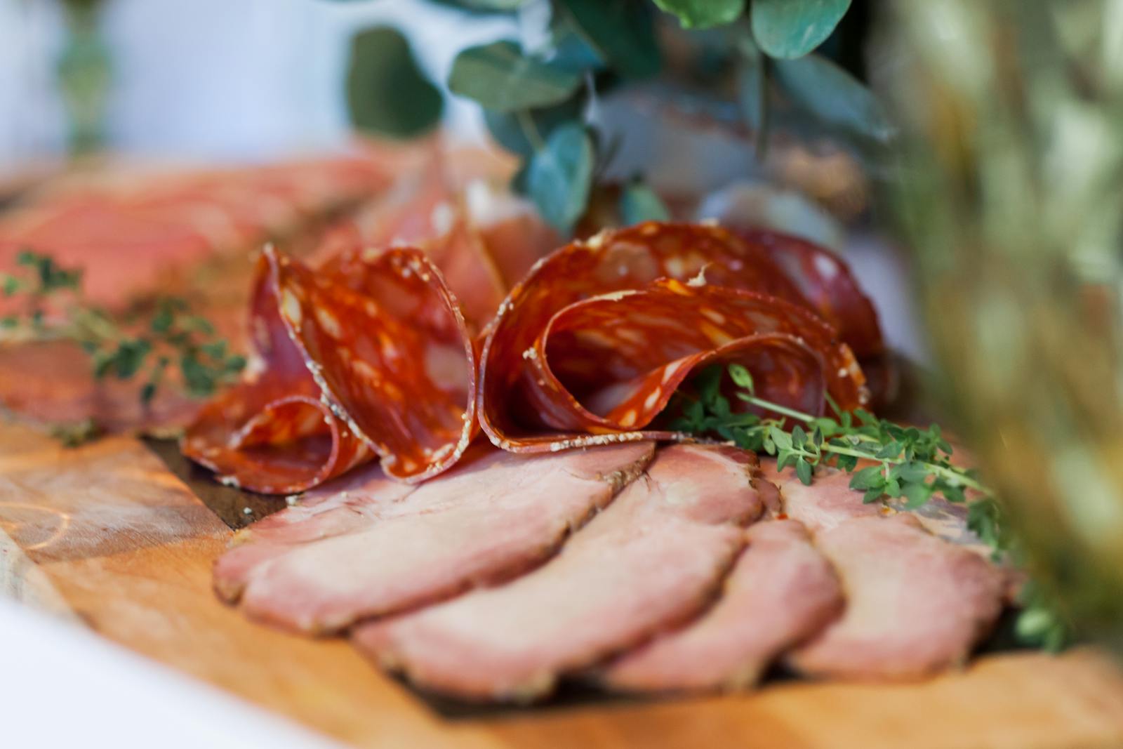 Sliced cured meat detail with rosemary